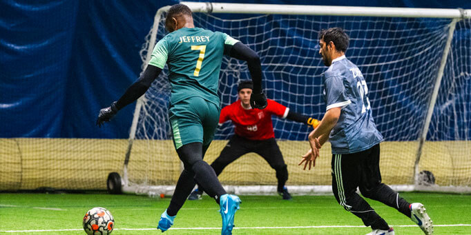 Tuesday men's indoor soccer league in Mississauga at Erindale with players advancing the ball